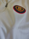 Manchester United crest patch on white fabric of a track jacket
